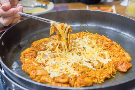 "Dak galbi" traditional korean food, Stir fried spicy pork with vegetable and ramen and cheese.の写真素材