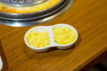 Cheese in white bowl on wood table.の写真素材