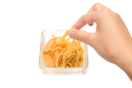 Hand picking spaghetti in glass bowl isolated on white background.の写真素材