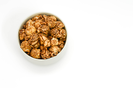 Chocolate popcorn in white Bowl on white background. copy space.の写真素材