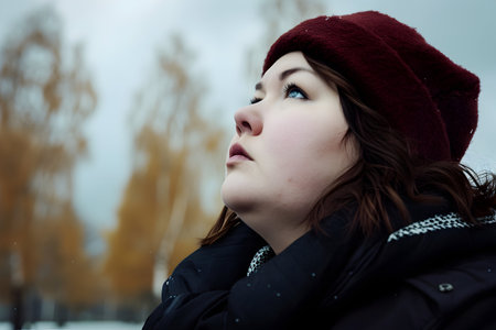 close portrait of a fat young woman in warm clothes in the parkの素材