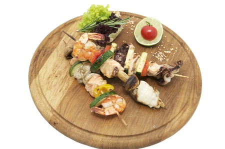 skewers of seafood on a wooden platter in a restaurantの写真素材