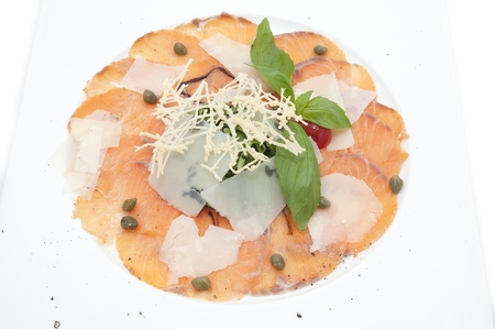 Slices of salmon with herbs and cheese on a white plateの写真素材