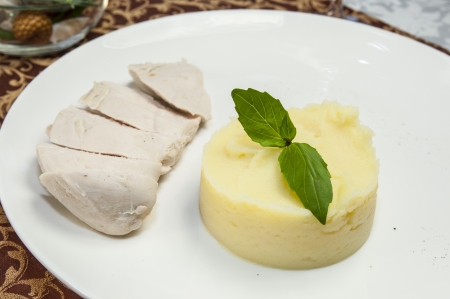 chicken and mashed potatoes on the table in a restaurantの写真素材