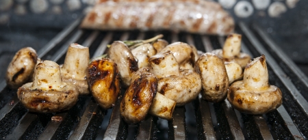 Cooking mushrooms on the grill in the restaurantの写真素材