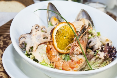salad with vegetables and seafood on the table in a restaurantの写真素材
