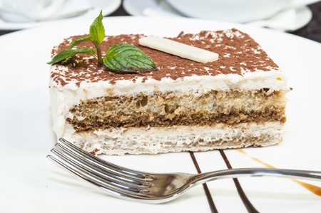 tiramisu on a white plate in a restaurantの写真素材