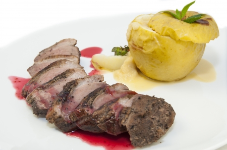 roast goose breast with apple sauce on white plateの写真素材