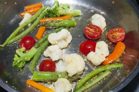 cook fresh vegetables in a pan in a restaurantの写真素材