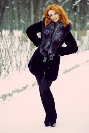 Vintage portrait of a young red-haired girl on the streetの写真素材