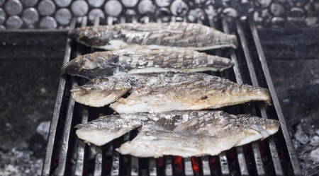 cooking fish on the grill in the restaurantの写真素材