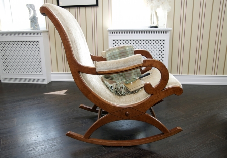 wooden rocking chair with a blanket and a bookのeditorial素材