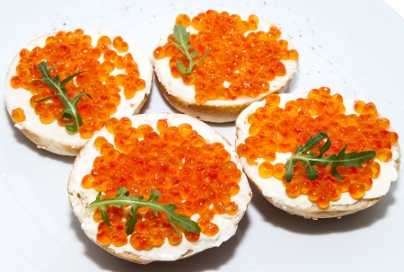 Sandwiches with red caviar on a white plate in a restaurantの写真素材