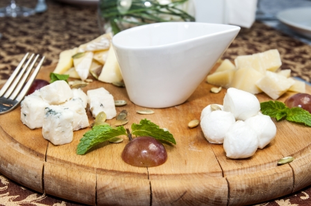 cheese plate with several varieties of cheese in the restaurantの写真素材