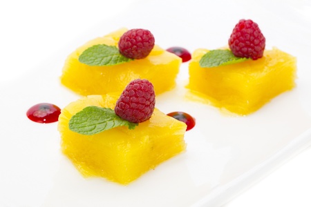 dessert of pineapple and decorated with raspberries on a white backgroundの写真素材