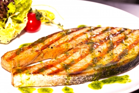 Salmon steak with herbs and lemon の写真素材