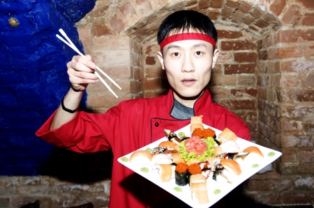Japanese chef with a plate of sushiの写真素材