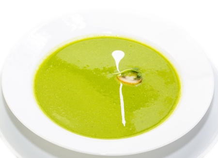 pea soup decorated with mushrooms and green on a white plate in a restaurantの写真素材
