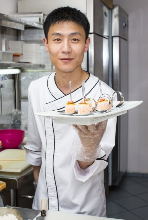 Japanese chef with a plate of sushiの写真素材
