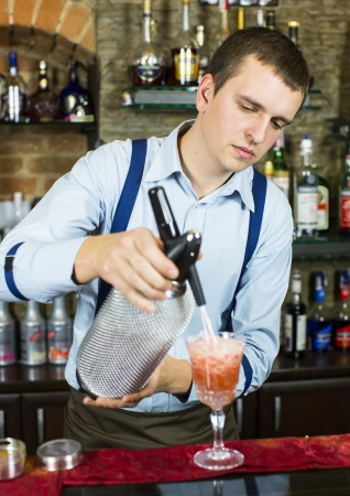 young man working as a bartender in a nightclub barの写真素材