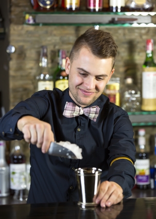 young man working as a bartender in a nightclub barの写真素材