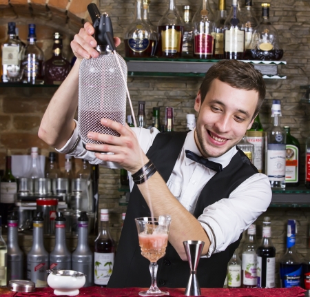 young man working as a bartender in a nightclub barの写真素材