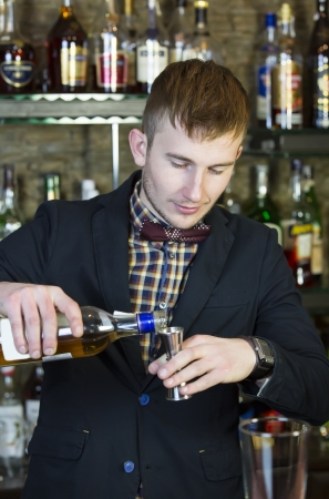 young man working as a bartender in a nightclub barの写真素材