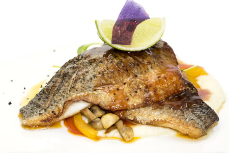 baked fish with vegetables and mushrooms in a restaurantの写真素材