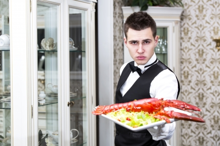 waiter with a tray of food in the restaurant hallの写真素材