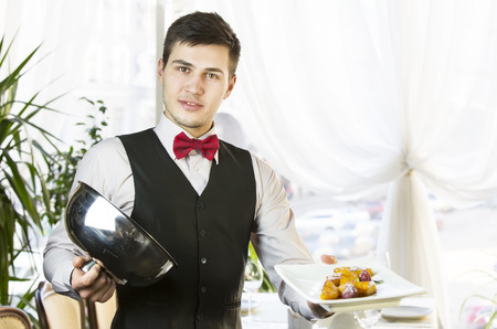 waiter with a tray of food in the restaurant hall