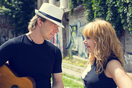 guy with a guitar and a woman in the streetの写真素材