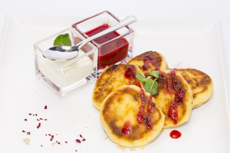 cheesecakes with sour cream and jam on table in restaurantの写真素材
