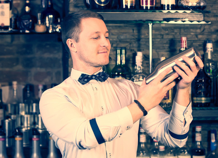 young man working as a bartender in a nightclub barの写真素材