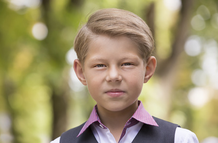 Portrait of a boy on a background of green natureの写真素材
