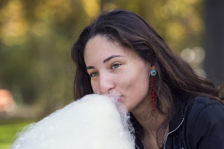 young girl eating cotton candyの写真素材