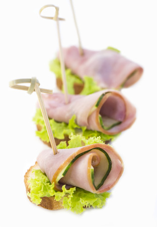 Canapes of cheese vegetables meat and seafood on white backgroundの写真素材