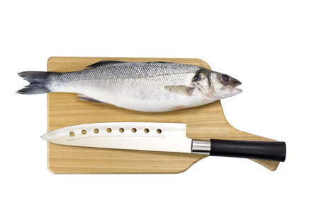 raw fish on a cutting board and knifeの写真素材
