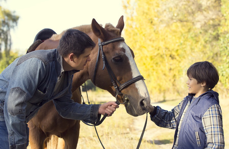 horse ride young guy autumn forestの写真素材