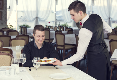 young man having dinner in a restaurantの写真素材