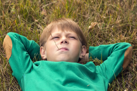 Portrait of a boy on a background of green natureの写真素材