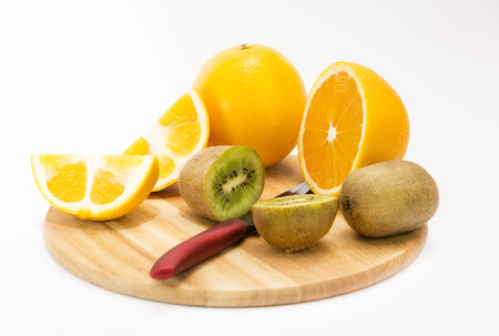kiwi and orange on a cutting boardの写真素材