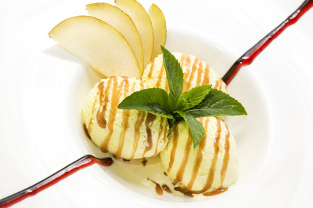 ice cream with caramel sauce and mint on a white backgroundの写真素材