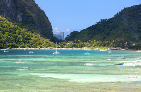 wooden boat in a bay surrounded by cliffsの写真素材