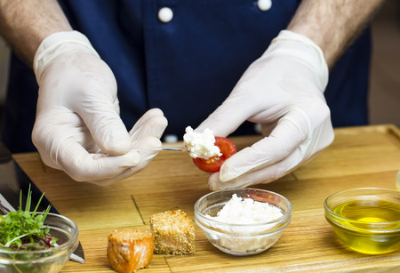 cook prepares canapes in the kitchen at the restaurantの写真素材