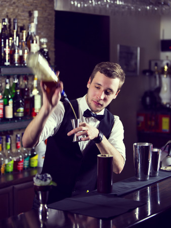 young man working as a bartender in a nightclub barの写真素材