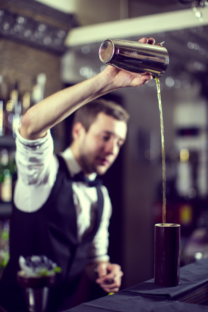 young man working as a bartender in a nightclub barの写真素材