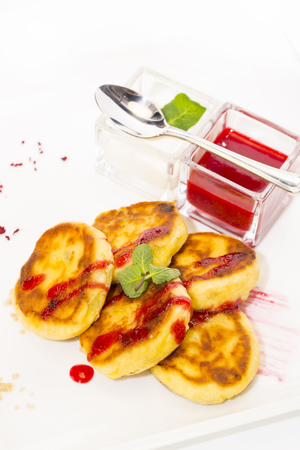 cheesecakes with sour cream and jam on table in restaurantの写真素材