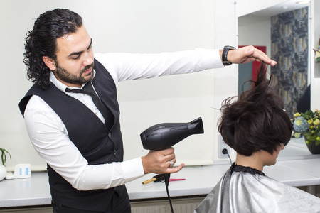 Hairdresser makes hair woman in a beauty salonの写真素材