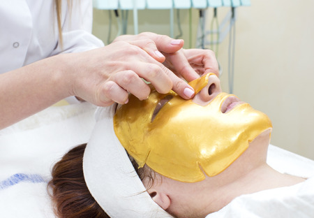 gold mask cosmetic procedure in the beauty salonの写真素材