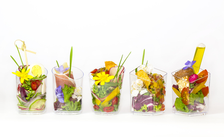 mini canapes in plastic cups decorated with edible flowers